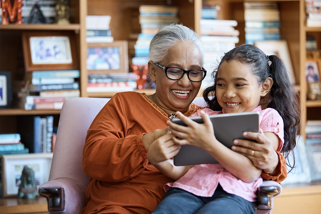 grandmother and granddaughter using device